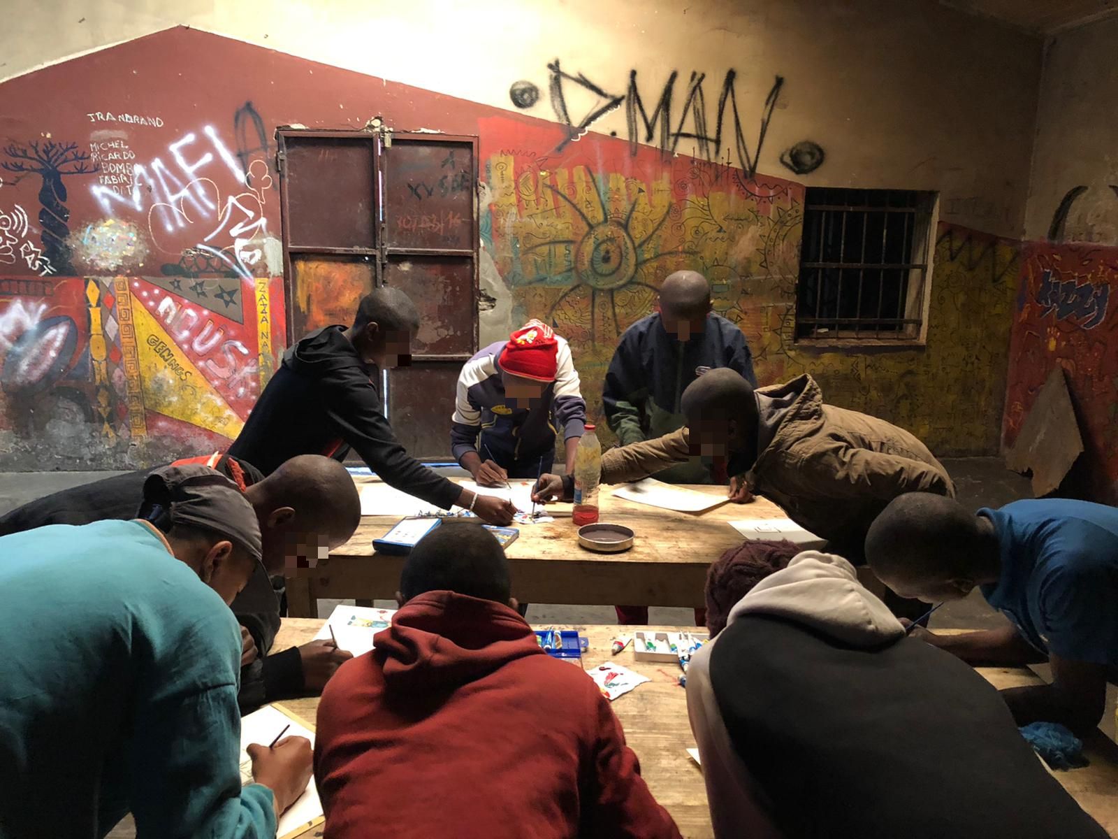children drawing at desks in class