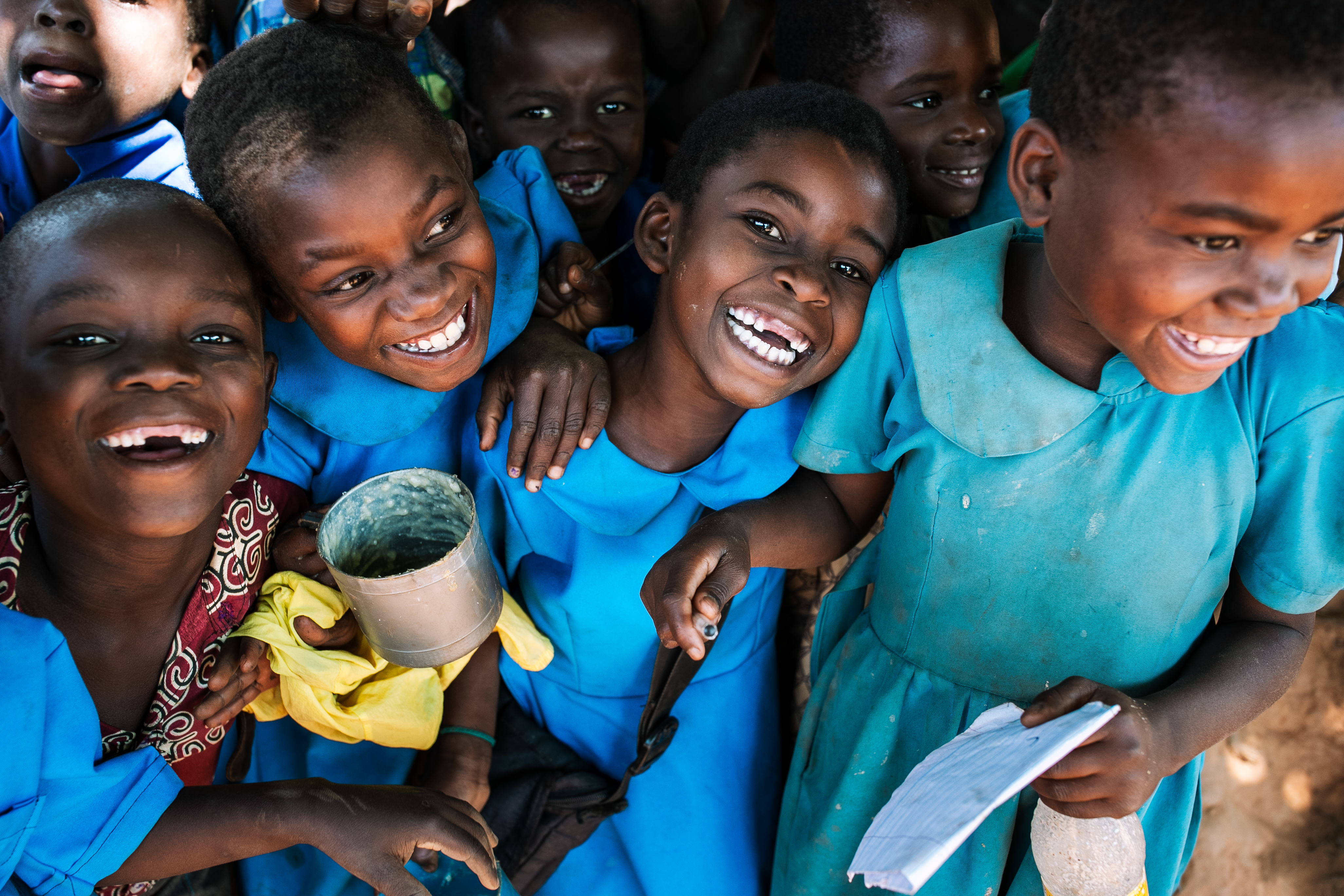 Children receiving a meal, smiling and laughing together.