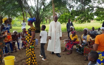 Bishop Karnley walking amongst a group of children outdoors