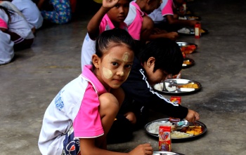 A girl sits down to eat in Thailand