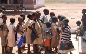 Children in Benin waiting to be served Mary's Meals at school.