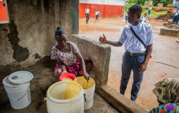 Momo, a school pupil from Liberia being served Mary's Meals in his place of education.