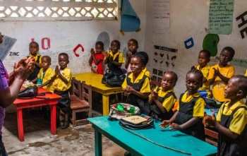 A classroom of children enjoying a lesson being taught by their teacher in a school in Liberia. 