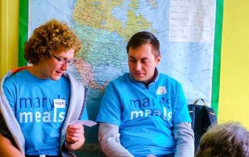 Two volunteers in discussion at a Mary's Meals event