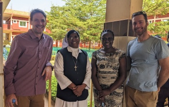 Sister Gracy standing with Mary's Meals partners looking into camera. 