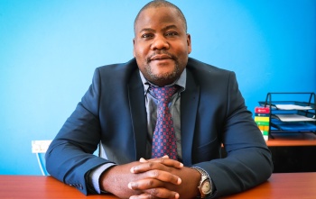 Panji Kajani, Country Director for Zambia and Zimbabwe, sitting at their desk. 