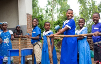 children in Malawi line up for food at school