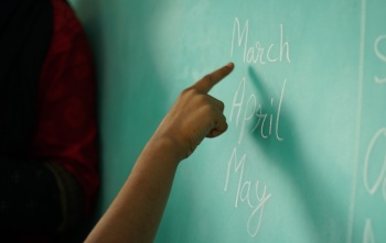 A finger points at a blackboard