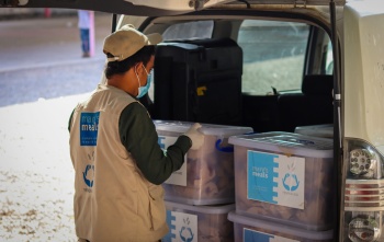a volunteer loads a car with supplies in Yemen