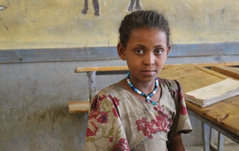 Image of Mahlet sitting in a classroom looking into camera. 