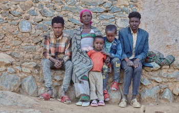  Letemariam and her family sitting looking directly into the camera.