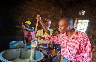 volunteers stirring a large cauldron of porridge