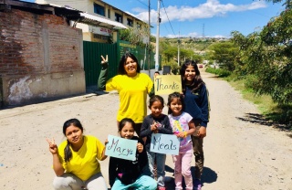 a group of children posing for the camera and giving 'peace' signs