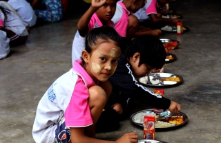 A girl sits down to eat in Thailand