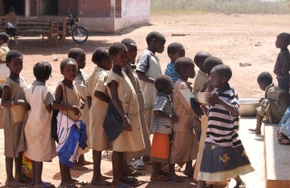 Children in Benin waiting to be served Mary's Meals at school.