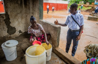 Momo, a school pupil from Liberia being served Mary's Meals in his place of education.