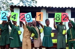 Children in Zimbabwe lined up to celebrate Mary's Meals reaching a new number of children being served nutritious school meals.