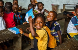 A happy child smiles with friends in class