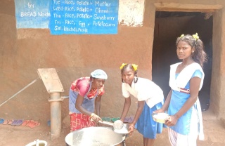 Arushi with a friend, receiving their meal from a volunteer.