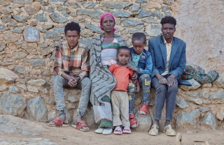 Letemariam and her family sitting looking directly into the camera.