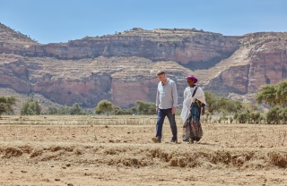 a man and woman walking in harsh looking desert climate