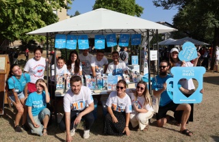 Image of young Mary's Meals supporters and volunteers manning a stall for Mary's Meals