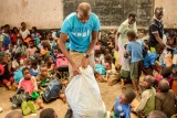 Mary's Meals staff member opening a large sack