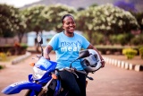 A school feeding officer rests against her motorbike