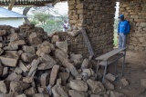 Mary's Meals volunteer standing in a building where one of the walls has collapsed.