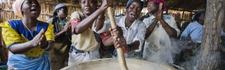 Mary's Meals volunteer cooks from Malawi preparing porridge to serve to school children. 