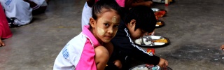 A girl sits down to eat in Thailand