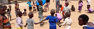 young children outdoors holding hands in a circle formation