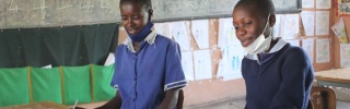 Two children from Zambia learning and reading in their classroom.