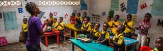 A classroom of children enjoying a lesson being taught by their teacher in a school in Liberia. 