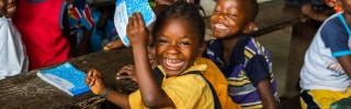 A happy child smiles with friends in class