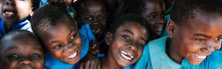 Children receiving a meal, smiling and laughing together. 