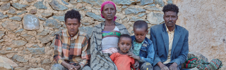Letemariam and her family sitting looking directly into the camera.