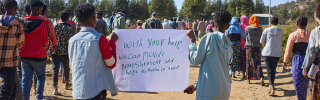 Children holding up a sign asking for help.