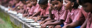 a group of young Indian children sitting in a line