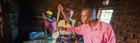 volunteers stirring a large cauldron of porridge