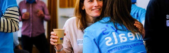 Two volunteers embrace at a Mary's Meals event