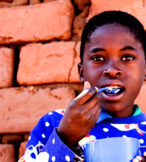A boy enjoys food from Mary's Meals