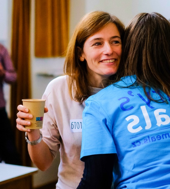 Two volunteers embrace at a Mary's Meals event