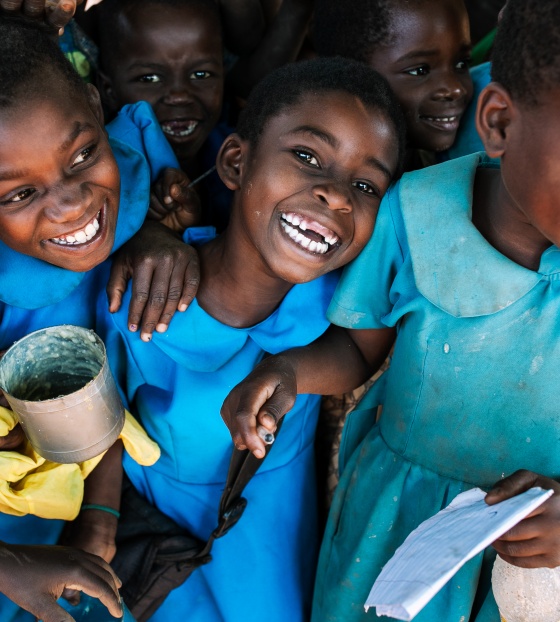 Children receiving a meal, smiling and laughing together. 
