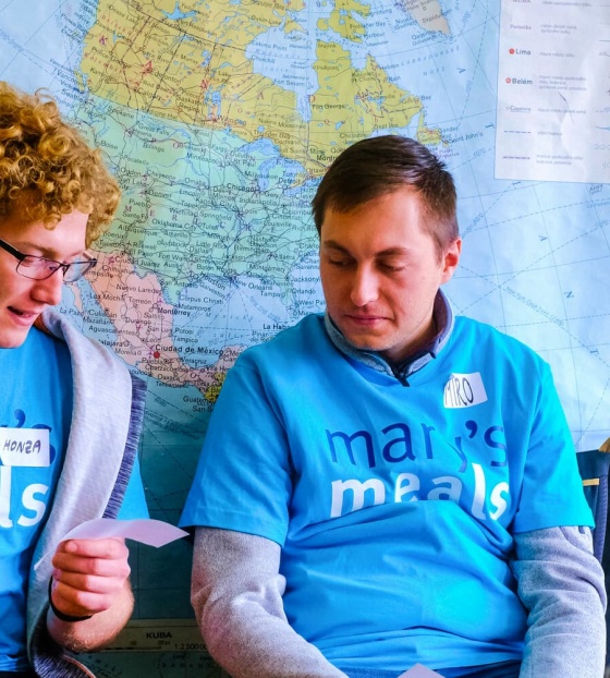 Two volunteers in discussion at a Mary's Meals event