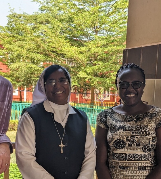 Sister Grace standing with Mary's Meals partners looking into camera. 