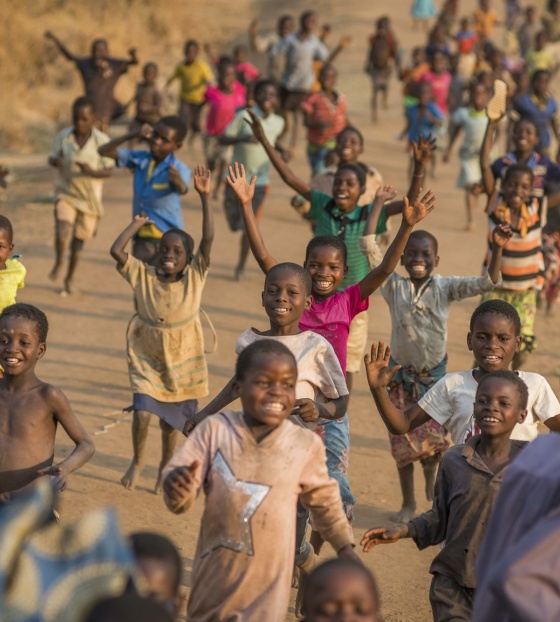 Children run together as they play outside a school