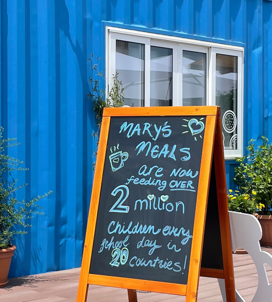 Image of the chalkboard outside of the blue container visitor centre for Mary's Meals in Medjugorje. 