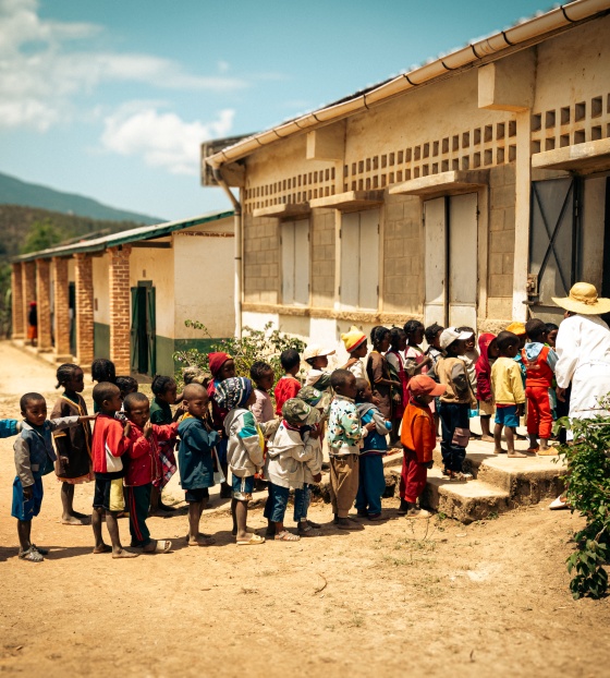 children queuing in a line outside a building