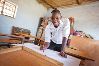 A child from Zambia enjoying drawing while at school. 